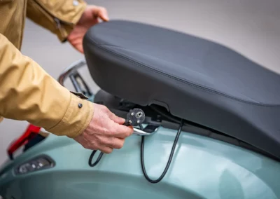 Une prise intégrée dans le coffre et un passage de selle astucieusement creusé permet de mettre le scooter en charge sans retirer la batterie.